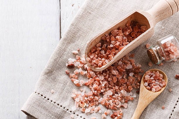 Himalayan pink salt over white wooden background stock photo