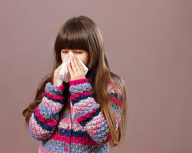 istock Little girl blowing nose 510015636