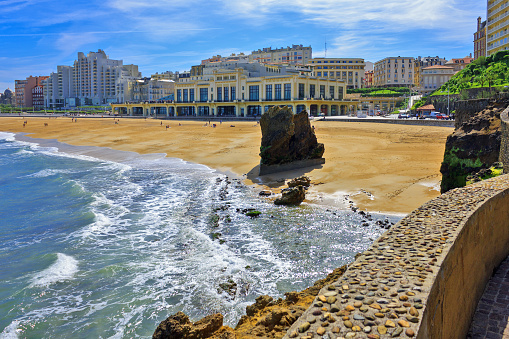 The main beach of Biarritz ( Grande Plage ), where the most important surf events of Europe take place. Gulf of Biscay, South West France(Pyrenees-Atlantiques, Aquitaine). Some unidentifiable people on the beach and the promenade. Sunny spring day.