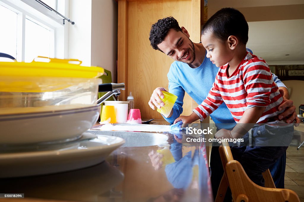 Son Helping Father To Wash Dishes In Kitchen Sink Family Stock Photo