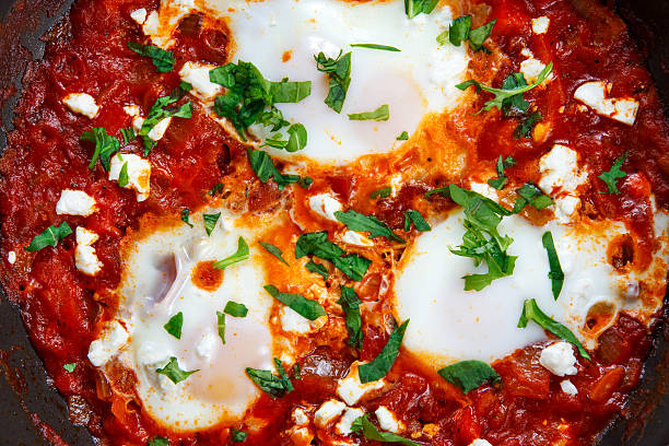 istock Fresh Eggs poached, tomato sauce. red, yellow pepper, onion 510018626