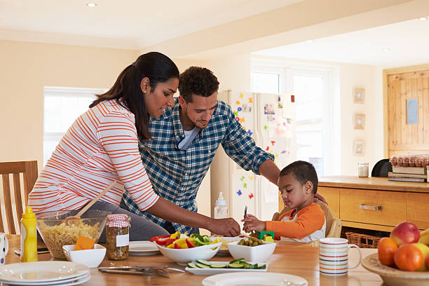 istock Family Sitting At Table In Kitchen Eating Meal With Son 510019322