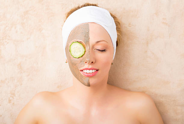 Beautiful woman with facial mask at spa studio Beautiful woman with facial mask at spa studio women facial mask mud cucumber stock pictures, royalty-free photos & images