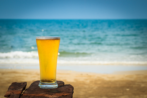 Cold beer on wooden  in front the sea of Thailand