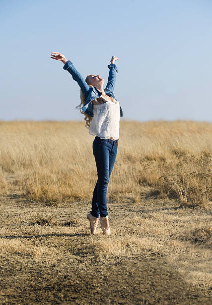istock Beautiful ballerina dancing in field in sunshine 510040421