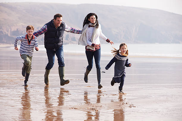 istock Family Running Along Winter Beach 510040953