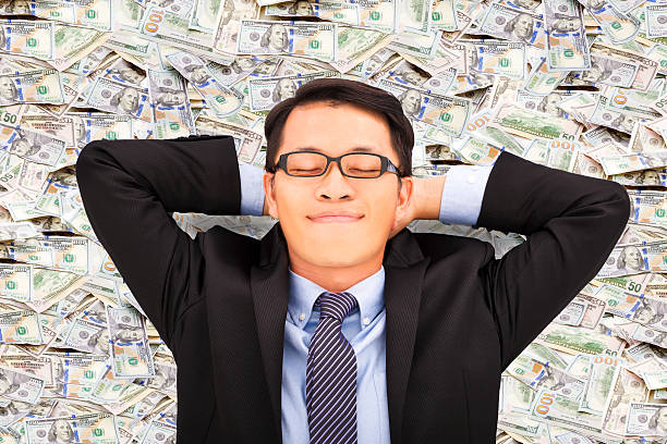 business man enjoying and lying on the money stock photo