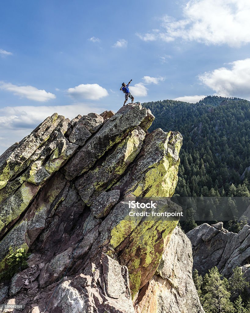 Climber Posing on top of Mountain A rock climber is posing on the top of a rock face. Boulder - Colorado Stock Photo