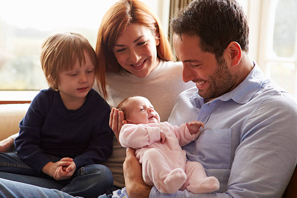 istock Family Sitting On Sofa With Newborn Baby 510042281