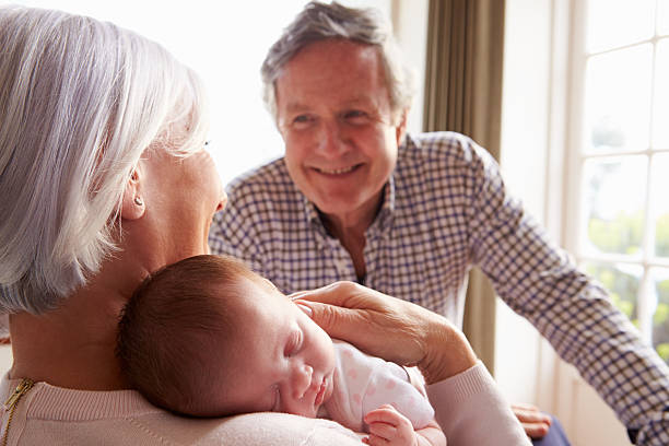 Grandparents Holding Sleeping Newborn Baby Granddaughter Grandparents Holding Sleeping Newborn Baby Granddaughter Smiling sleeping grandpa stock pictures, royalty-free photos & images