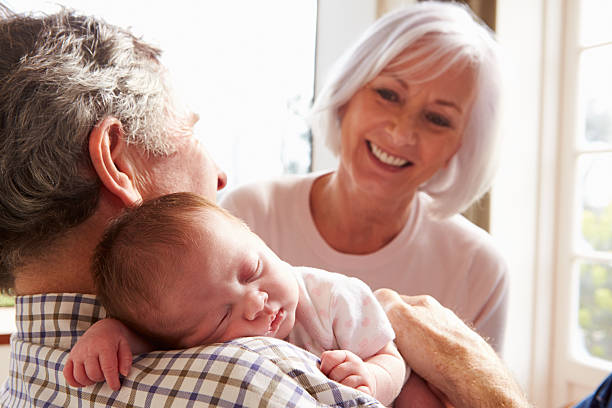 Grandparents Holding Sleeping Newborn Baby Granddaughter Grandparents Holding Sleeping Newborn Baby Granddaughter Smiling sleeping grandpa stock pictures, royalty-free photos & images