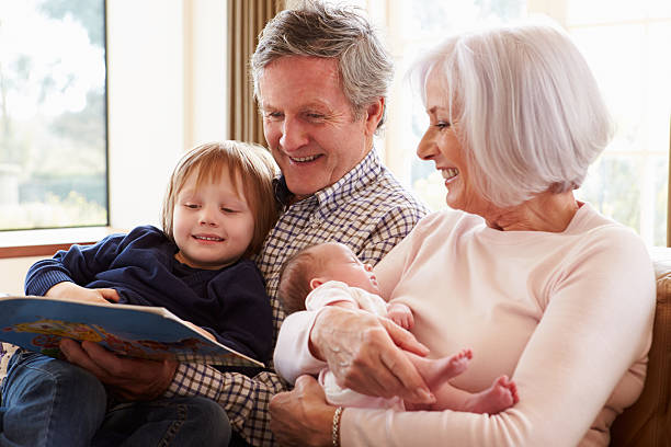 Grandparents With Grandson And Newborn Baby Granddaughter Grandparents With Grandson And Newborn Baby Granddaughter Smiling sleeping grandpa stock pictures, royalty-free photos & images