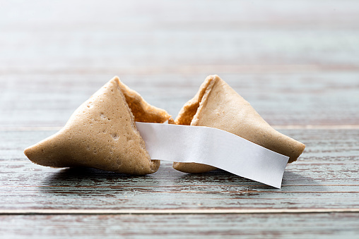 Fortune cookie with blank slip isolated on table.    