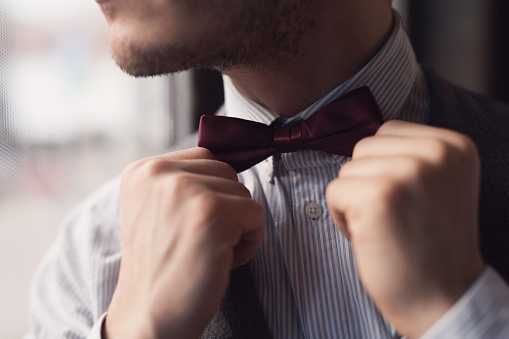 Close-up of an elegant man fixing his bow tie.