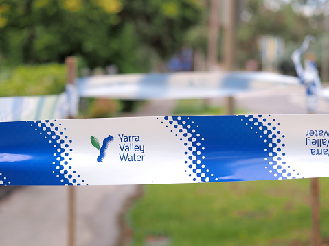 Melbourne, Australia - January 31, 2016: Safety tape of  the Yarra Valley Water authority at a mains water leakage