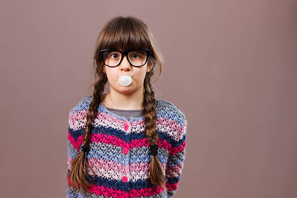 мало всезнайка девочка блоуинг-розовый - chewing gum bubble blowing little girls стоковые фото и изображения