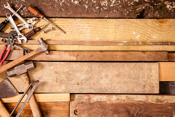 istock Craftsperson, carpenter tools to left side. Old wooden boards background. 510062515