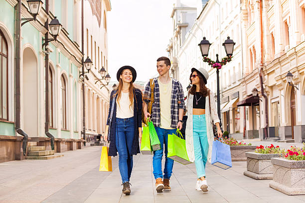 istock Three happy friends walking with shopping bags 510063082