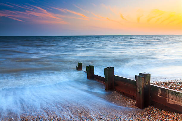 Golden sunset illuminating the beach and groynes at whitstable, england