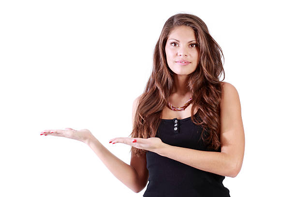 istock Young brunette woman shows to left  and looks at camera 510063378