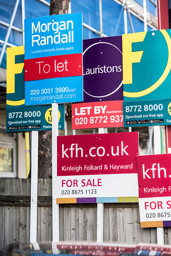 London, England, United Kingdom - October 31, 2015: Estate Agency For Sale, To Let and Sold advertising hoarding boards outside residential housing.