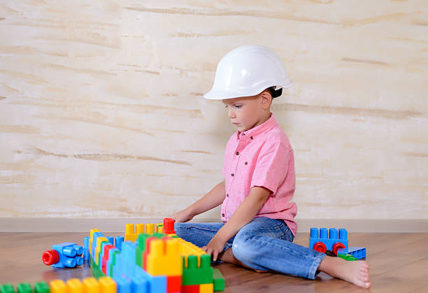 istock Young boy wearing hardhat playing indoors 510064634