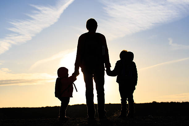 istock father and two kids travel at sunset 510065032