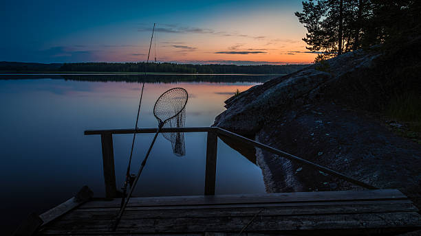 Fishing equipment on a dock at sunset stock photo
