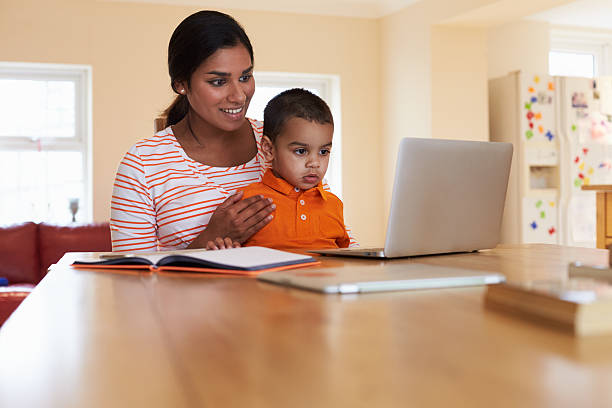 istock Mother And Son In Kitchen Looking At Laptop Together 510066028