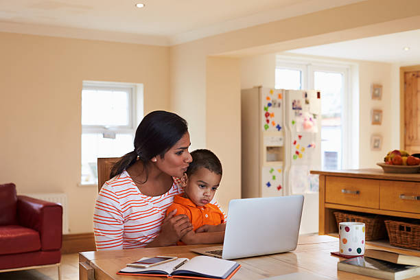 istock Mother And Son In Kitchen Looking At Laptop Together 510066114