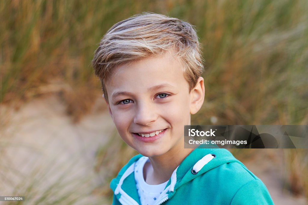 Head And Shoulders Portrait Of Boy By Sand Dunes 8-9 Years Stock Photo