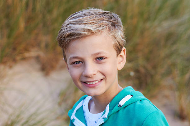 Head And Shoulders Portrait Of Boy By Sand Dunes stock photo