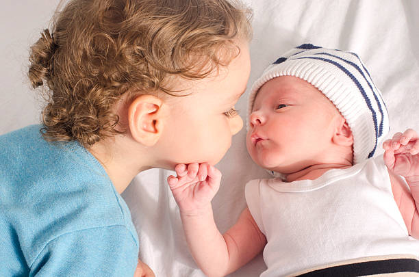 Big brother kissing his little sibling. stock photo