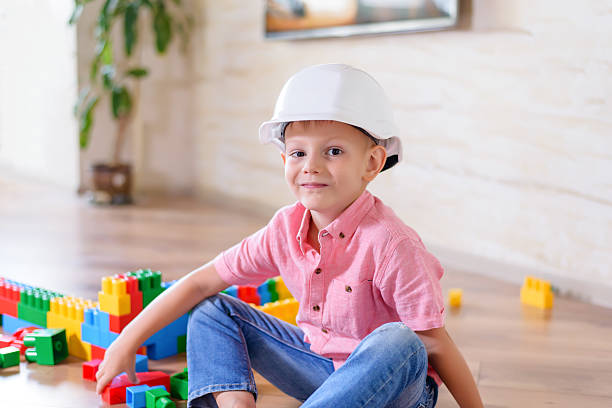 istock Happy little boy wearing plastic white hard hat 510067362