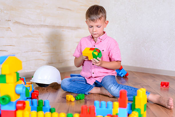istock Cute cheeky young boy playing with building blocks 510067700