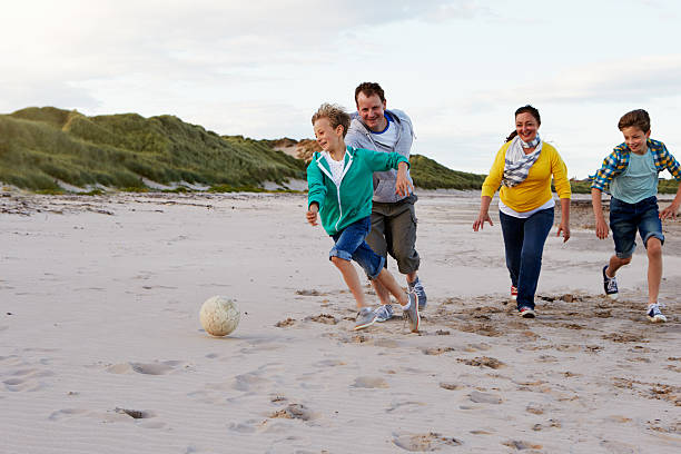 istock Parents Playing Soccer With Children On Beach 510068672