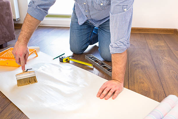 istock Handyman measuring wallpaper to cut 510069126
