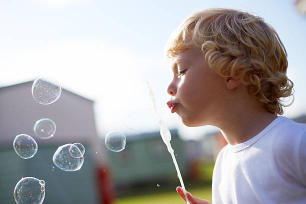 istock Close Up Of Young Boy Blowing Bubbles 510070020