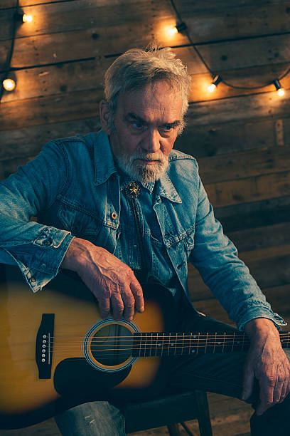 istock Senior guitarist with beard sitting on chair. 510070550