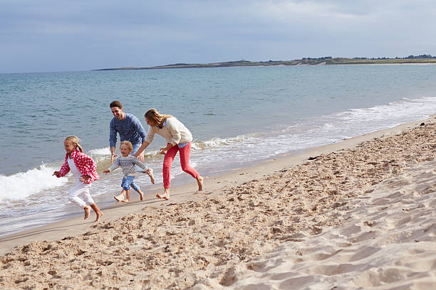 istock Family On Beach Vacation Running By Sea 510070708
