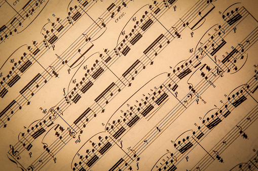 Old classical sheet music has a vintage tone and texture to it; horizontal format