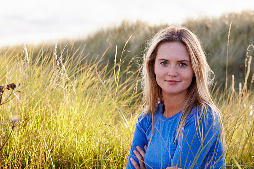 Portrait Of Woman Sitting In Sand Dunes