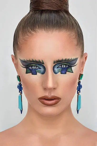 Portrait of beautiful young girl, lady, woman, model. Fantasy, bright, stylish, makeup. Cubism, geometry style. Expressive eyebrows, colored blue lines, long earrings Fashion, creative look.