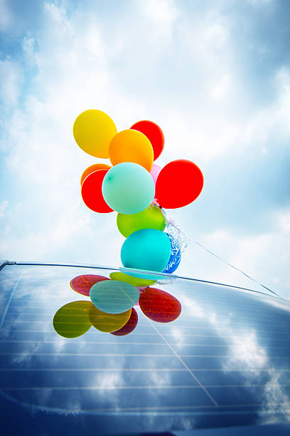 Colorful balloons on car roof stock photo