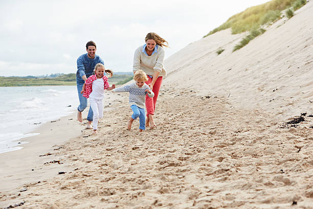 istock Family On Beach Vacation Running By Sea 510078054