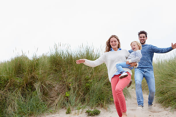 istock Family Running Through Sand Dunes Together 510079642