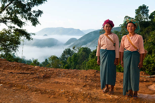 Laotian mom with her daughter, wearing traditional Lantan tribe clothes,  walking together in a Lantan village in Northern Laos
