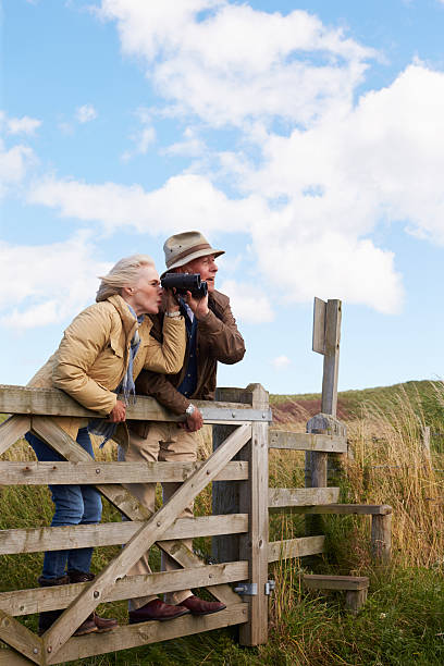 istock Senior Couple With Binoculars Walking In Countryside 510080472