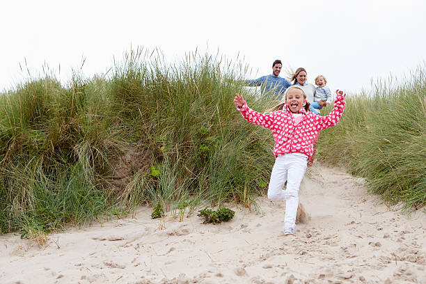 istock Family Running Through Sand Dunes Together 510080546