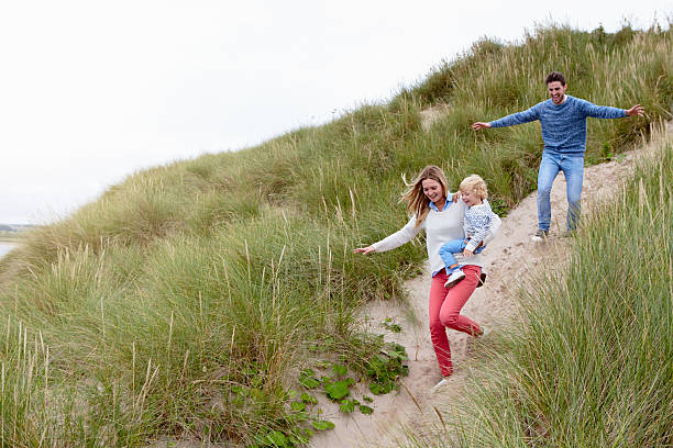 istock Family Running Through Sand Dunes Together 510080658